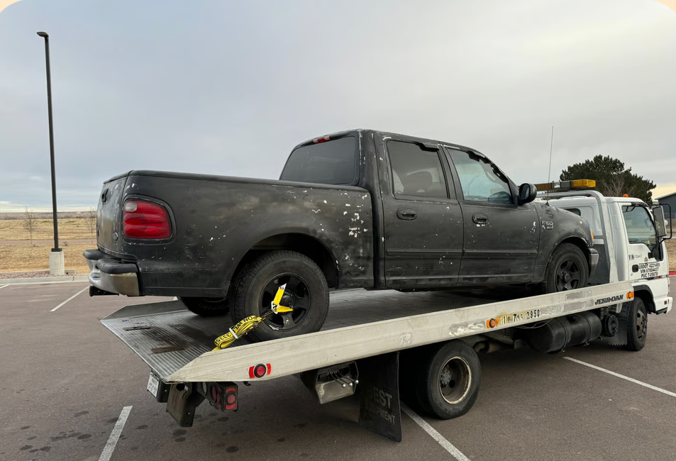 Flatbed truck towing a pickup in Colorado Springs
